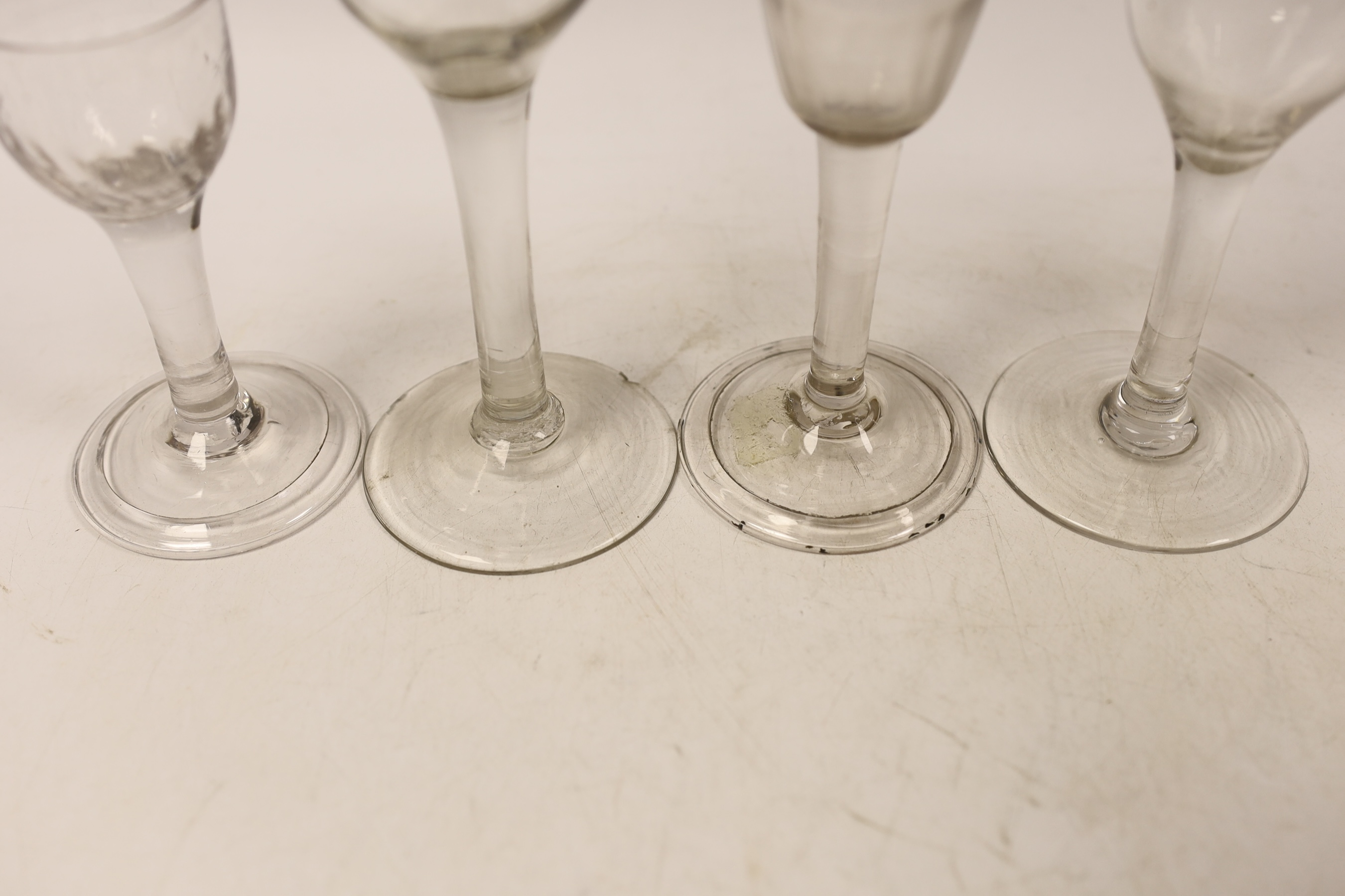 Four plain stem wine and cordial glasses, first half 18th century, two examples with folded feet, tallest 16.5cm